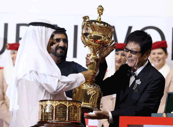 His Highness Sheikh Mohammed bin Rashid Al Maktoum, Vice-President and Prime Minister of the UAE and Ruler of Dubai and Sheikh Hamdan bin Rashid Al Maktoum, Deputy Ruler of Dubai, UAE Minister of Finance and Industry, presenting the Dubai World Cup trophy to Yoshimi Ichikawa, owner of the winning horse Victoire Pisa at Meydan on Saturday. (PATRICK CASTILLO)