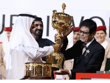 His Highness Sheikh Mohammed bin Rashid Al Maktoum, Vice-President and Prime Minister of the UAE and Ruler of Dubai and Sheikh Hamdan bin Rashid Al Maktoum, Deputy Ruler of Dubai, UAE Minister of Finance and Industry, presenting the Dubai World Cup trophy to Yoshimi Ichikawa, owner of the winning horse Victoire Pisa ridden by Mirco Demuro at Meydan on Saturday. (PATRICK CASTILLO)