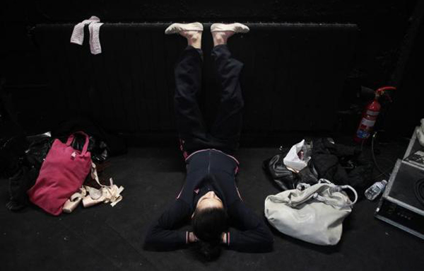 A dancer stretches her feet as she waits for her turn to dance during an audition for "The Red Shoes" production of Ballet Madrid in Madrid. (REUTERS)