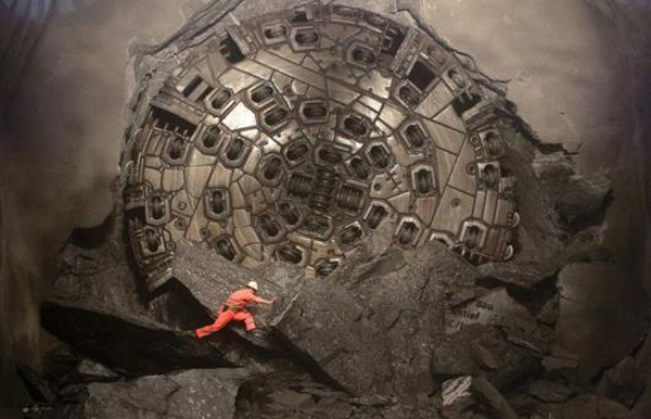 A miner climbs on excavated rocks after a giant drill machine broke through at the final section Sedrun-Faido, at the construction site of the NEAT Gotthard Base Tunnel. Crossing the Alps, the world's longest train tunnel should become operational at the end of 2016. The project consists of two parallel single track tunnels, each of a length of 57 km (35 miles). (REUTERS)