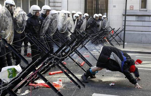 A demonstrator shows his bottom to riot police during a protest by European workers and trade union representatives to demand better job protection in the European Union countries in Brussels. Tens of thousands of people marched through Brussels on Thursday to urge European leaders holding a two-day summit in the Belgian capital to scrap or ease austerity measures, which unions say will slow economic recovery and punish the poor. (REUTERS)
