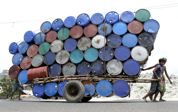 Bangladeshi labourers pull a cart of used containers to the market in Dhaka April 26, 2007. (REUTERS)