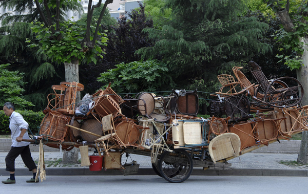 A vendor pulls a cart loaded with various rattan chairs for sale on a street in Shanghai May 22, 2009. (REUTERS)
