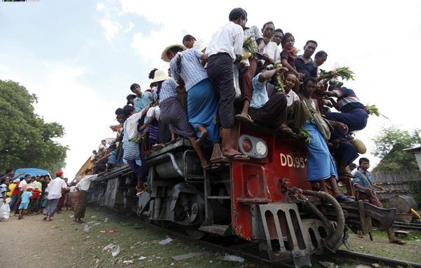 People try to board a crowded passenger train to take part in the Nat, or spirits, festival, at Taungbyone station, near Mandalay August 21, 2010. The festival is popular with young people for merrymaking and drinking. Spirit mediums take part in the festival and people of all ages can join in the Nat dance. (REUTERS)