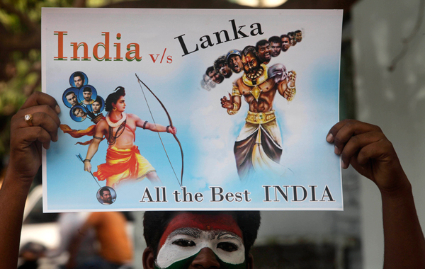 An Indian cricket fan holds a placard depicting Sri Lanka as the demon God Ravana, right, and India as Hindu God Rama, ahead of the ICC World Cup cricket final between India and Sri Lanka, in Hyderabad, India. (AP)
