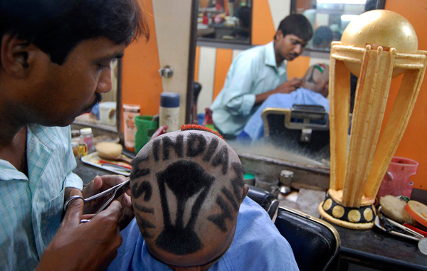 An Indian cricket fan gets a haircut displaying his support for the Indian cricket team, in Howrah, on the outskirts of Kolkata, India. (AP)