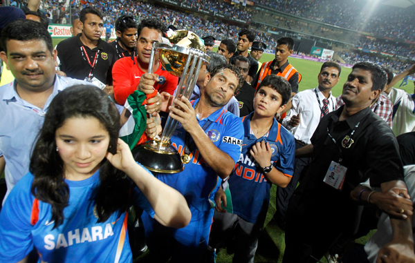 India's Sachin Tendulkar holds the trophy as he walks with his daughter Sara (bottom L) and son Arjun after India won their ICC Cricket World Cup final match against Sri Lanka in Mumbai. (REUTERS)