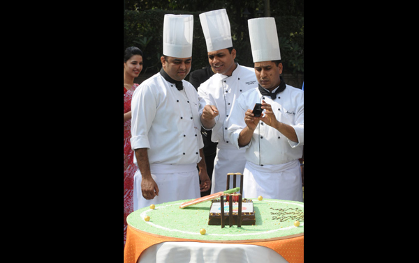 Indian chefs take photographs of a cake styled with cricket ball, cricket bat and wickets at a function in New Delhi. (AFP)