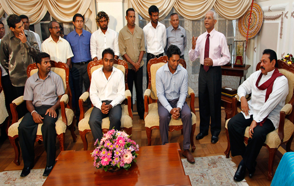 Sri Lankan President Mahinda Rajapaksa, seated right, and the members of Sri Lankan cricket team look on during a meeting at Rajapaksa's residence in Colombo, Sri Lanka. (AP)