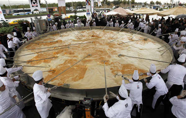 Largest omelette: Chefs cook an omelette during a Guinness World Records attempt for the world's largest omelette in Ankara October 8, 2010. The Turkish Egg Producers Association celebrated World Egg Day on Friday with an attempt to cook the world's largest omelette weighing 6 tonnes with a total of 432 litres of oil and 110,000 eggs used. (REUTERS)
