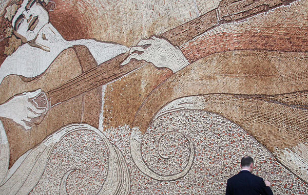 Largest mosaic made of corks: A man looks at the largest mosaic made of corks created by Albanian artist Saimir Strati in Tirana September 4, 2008. Strati glued 229,764 corks of various shapes and colours over a plastic banner measuring 12.94 metres by 7.1 metres to make the artpiece "Romeo with a crown of grapes playing the guitar while dancing with the sea and the sun". He worked 14 hours a day for 28 days. (REUTERS)