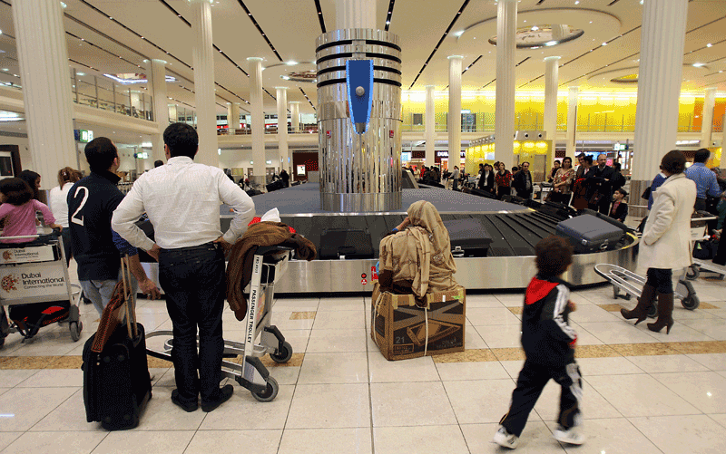 Passengers claim their baggage upon their arrival to Dubai International Airport Terminal. (FILE)