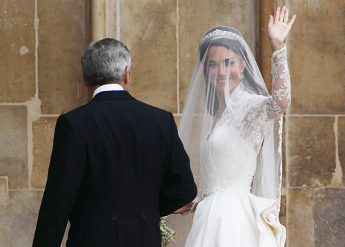 Catherine Middleton waves to the crowds as she arrives with her father Michael Middleton to attend the Royal Wedding of Prince William to Catherine Middleton at Westminster Abbey on April 29, 2011 in London.  Kate Middleton's ivory and lace wedding dress was designed by Sarah Burton, creative director at the fashion house Alexander McQueen, the palace announced Friday (Getty Images)
