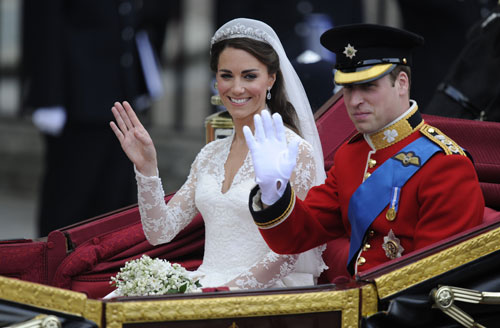 Britain's Prince William and his wife Kate, Duchess of Cambridge, wave as they travel in the 1902 State Landau carriage along the Processional Route to Buckingham Palace, in London, on April 29, 2011 (AFP)