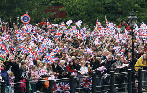 Spectators wave Union Jack flags near Buckingham Palace before the Royal Wedding of Prince William to Catherine Middleton at Westminster Abbey on April 29, 2011 in London, England. The marriage of the second in line to the British throne is to be led by the Archbishop of Canterbury and will be attended by 1900 guests, including foreign Royal family members and heads of state. Thousands of well-wishers from around the world have also flocked to London to witness the spectacle and pageantry of the Royal Wedding (Getty Images)