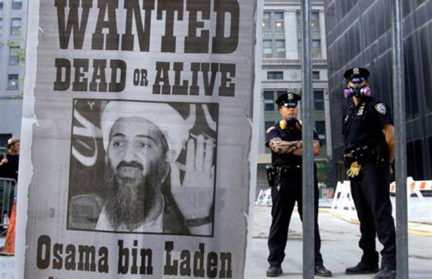 New York police stand near a wanted poster printed by on a full page of a New York newspaper for Saudi-born militant Osama bin Laden in the financial district of New York, in this file photo from September 18, 2001. (REUTERS)