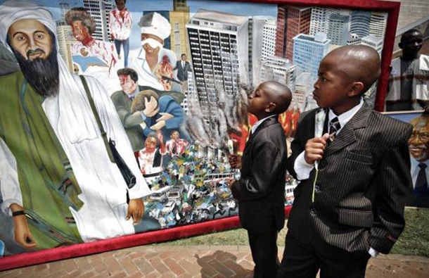 Victor Juma (R), 12, and his brother Jaram Rajab, 10, who lost their father, Laurence Olum Ochieng, in the bombing of the U.S. embassy a decade ago, look at a memorial painting marking the 10th anniversary of the attack in Nairobi, August 7, 2008. (REUTERS)