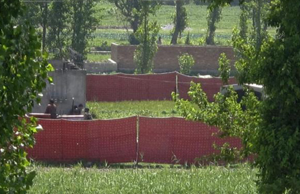 Surrounded by red fabric, a compound is seen where locals reported a firefight took place overnight in Abbotabad, located in Pakistan's Khyber Pakhtunkhwa province, May 2, 2011. (REUTERS)