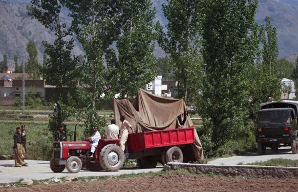 Soldiers escort covered debris as it is moved out by military vehicles from the compound within which al Qaeda leader Osama bin Laden was killed, in Abbottabad, May 2, 2011. (REUTERS)
