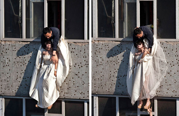 A 22-year-old woman in a wedding gown is grabbed by Guo Zhongfan, a local community officer, as she attempts to kill herself by jumping out of a seven-storey residential building in Changchun, Jilin province. (REUTERS)