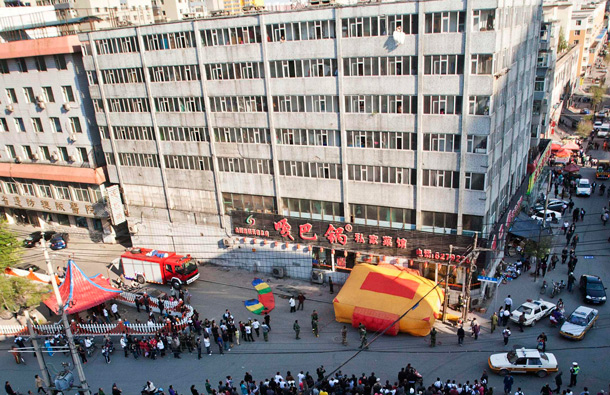 A 22-year-old woman (top R) in a wedding gown sits on a windowsill before attempting to kill herself by jumping out of a seven-storey residential building in Changchun, Jilin province. (REUTERS)