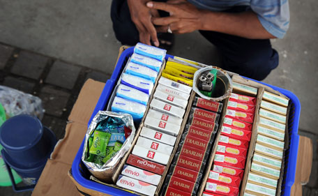 A cigarette vendor sits beside a tray containing various local tobacco brands at a Jakarta sidewalk on May 19, 2011. Cigarettes are often the second biggest item of household expenditure after food for Indonesia's poorest families. The country of some 240 million people is one of the strict major tobacco markets in the world and is paying the price in terms of growing rates of addiction, especially among women and children.  Cigarette consumption in Indonesia soared 47 percent in the 1990s, according to WHO. (AFP)