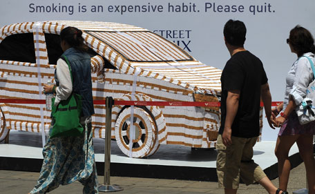 Shoppers walk past an installation in the design of a car, made from 200,000 sticks of cigarettes by anti-tobacco campaigners, at a shopping mall on the eve of World Anti-Tobacco Day in Mumbai on May 30, 2010. India is the world's second-largest producer and consumer of tobacco, according to the American Cancer Society and the World Lung Foundation. About a fifth of Indians, or 241 million people, use tobacco in some form. (AFP)