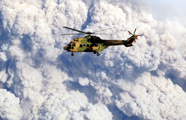 A military helicopter is backdropped by the cloud of ash billowing from Puyehue volcano in southern Chile, 870 km south of Santiago, as it flies near Rininahue village. (AFP)