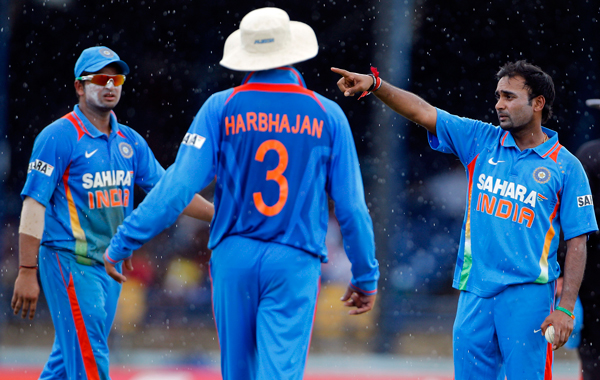 India's Amit Mishra, right, discusses field positions with captain Suresh Raina, left, and Harbhajan Singh during the second one-day international cricket match against West Indies in Port-of-Spain, Trinidad. (AP)
