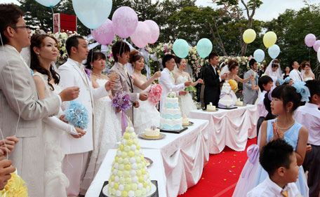 Ten couples who postponed their wedding ceremony because of the March 11 twin quake and tsunami disasters hold a joint wedding ceremony with 200 of their family and friends organised by civil wedding group All Japan Bridal Association in Kamaishi in Iwate prefecture on July 3, 2011. (AFP)