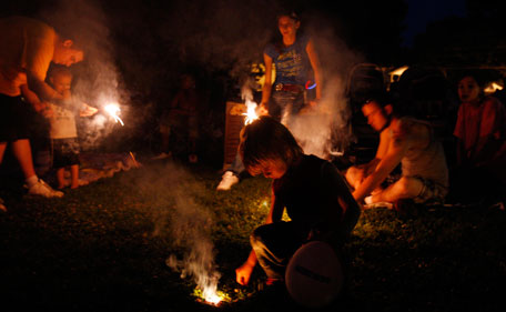 Dyllan Kimberlin (C), 4, plays with sparklers as he and his family wait to watch the Independence Day fireworks display in Independence, Iowa July 4, 2011.  (REUTERS)