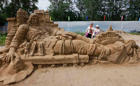 Visitors look at a sand sculpture called "Gulliver" at a park in Russia's Siberian city of Krasnoyarsk, July 6, 2011. Nine professional and amateur artists took part in a contest to build sand sculptures under the general theme of "The Carnival" and created works interpreting mythological plots, fairy-tales and cartoons.  (REUTERS)