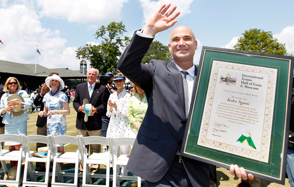 Tennis great Andre Agassi waves to the crowd with his plaque after being inducted to the International Tennis Hall of Fame in Newport, R.I. (AP)