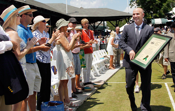 Tennis great Andre Agassi walks with his plaque after being inducted to the International Tennis Hall of Fame in Newport, R.I. (AP)