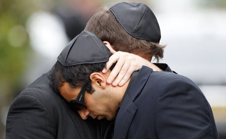 Mourners embrace as they leave the funeral service for Amy Winehouse at a cemetery in north London July 26, 2011. (REUTERS)