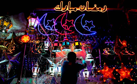 A street vendor plugs in decorations for Ramadan such as crescents, stars, lanterns and writing that reads in Arabic "Blessed Ramadan," top, in Amman, Jordan, early Friday July 22, 2011.  Ramadan, the holiest month in the Islamic calendar, during which Muslims fast from dawn to dusk, is celebrated as the period when the Quran, Islam's holy book, was revealed to the Prophet Muhammad about 1,400 years ago.  (AP)