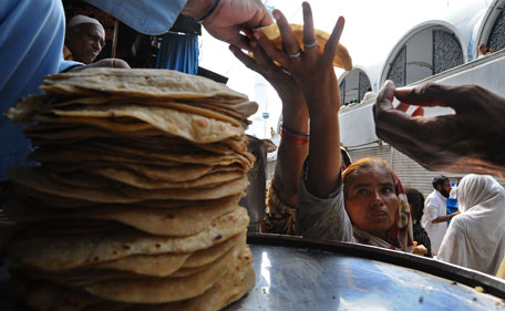 A Pakistani woman receives donated bread at a market ahead of the upcoming Muslim holy fasting month of Ramadan in Lahore on July 29, 2011. Muslims around the world abstain from eating, drinking and conducting sexual relations from sunrise to sunset during Ramadan, the holiest month in the Islamic calender. (AFP)