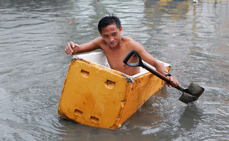 A man paddles a makeshift raft through a flooded street in Las Pinas, Metro Manila July 26, 2011. More than 100,000 families were displaced due to flooding, while 11 fishermen were missing in central Philippines as Typhoon Juaning battered the main Luzon island, forcing schools to close and grounding domestic flights and ferry services, disaster officials said on Tuesday.  (REUTERS)