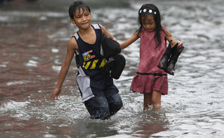 A boy and his younger sister wade through floodwaters in Malabon city, north of Manila, brought by Typhoon Nock-Ten or locally known as Juaning in Manila July 26, 2011. Seven people were reported killed and eleven fishermen went missing in the central Philippines as Typhoon Nock-Ten battered the main luzon island, forcing schools to close and grounding domestic flights and ferry services, disaster officials said on Tuesday.  (REUTERS)