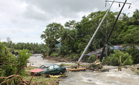 A car is swept along by floodwaters next to tilted electric posts on a damaged road, after typhoon Nock-Ten hit Daraga, Albay in central Philippines July 27, 2011. Typhoon Nock-Ten, locally known as Juaning, slammed into the eastern mountain areas of the Philippine main island of Luzon on Wednesday, killing 20 people and displacing more than 600,000 others due to flooding. (REUTERS)