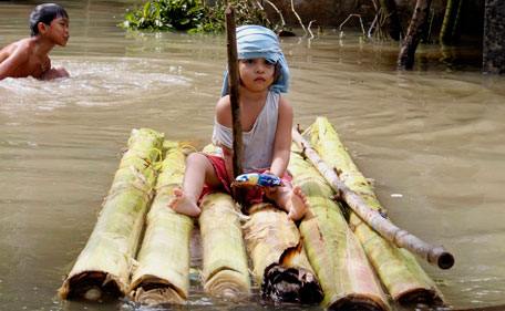A girl sits on a makeshift raft in a flooded street in Guinobatan, Albay province, central Philippines July 28, 2011. Typhoon Nock-Ten, locally named as Juaning, has killed at least 35 people, left dozens more missing and about 600,000 people displaced due to flooding after a three-day rampage across northeastern Philippines, disaster officials said. Picture taken July 28, 2011.  (REUTERS)