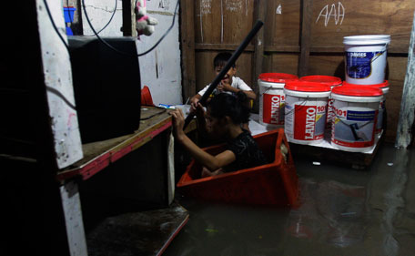 A young girl rides in a makeshift floater inside her house as flood water submerged low-lying areas Tuesday, Aug. 2, 2001 in suburban Quezon City, north of Manila, Philippines. A powerful typhoon is blowing away from the northern Philippines after killing at least four people even though it did not make landfall. (AP)