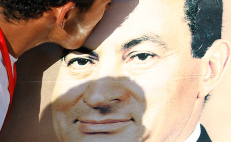 A supporter of former President Hosni Mubarak kisses a poster of him outside the police academy where his trial will take place, in Cairo August 3, 2011. Mubarak left hospital in Sharm el-Sheikh on Wednesday to travel to Cairo where he will be tried for conspiring to kill protesters, the first Arab ruler to be put in the dock since uprisings swept the region. (REUTERS)