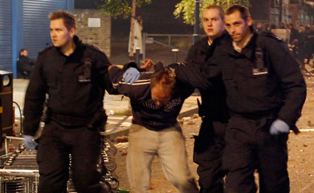 Police officers detain a man in Tottenham, north London August 7, 2011. Crowds attacked riot police and set two squad cars alight in north London on Saturday following a protest at the fatal shooting of a man by armed officers earlier in the week. (REUTERS)
