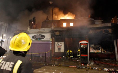 A firefighter watches as his colleagues tackle a fire in a building in Tottenham, north London August 7, 2011. Crowds attacked riot police and set two squad cars alight in north London on Saturday following a protest at the fatal shooting of a man by armed officers earlier in the week. (REUTERS)