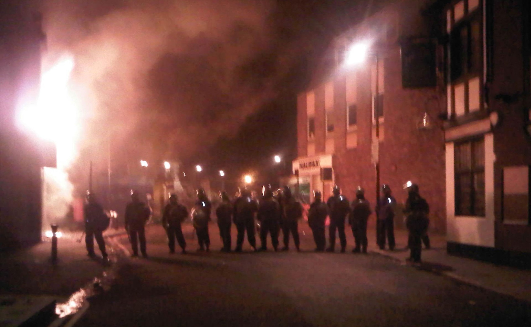 Riot policeman stand guard in Tottenham, north London, late Saturday, Aug. 6, 2011, after two patrol cars were attacked by members of a community where a young man was shot dead by police on Thursday took to the streets to demand "justice." Officers had been attempting to carry out an arrest under the Trident operational command unit, which deals with gun crime in the black community, according to the Independent Police Complaints Commission. (AP)