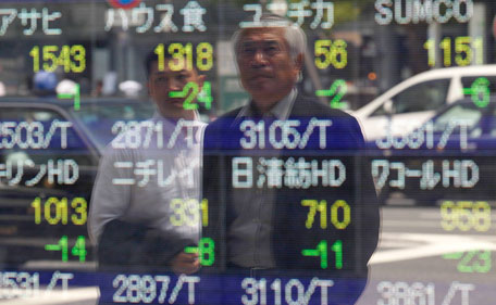 People are reflected on a stock index board outside a brokerage in Tokyo August 8, 2011. Japanese Finance Minister Yoshihiko Noda said on Monday that market trust in the dollar and US Treasuries has not wavered, signalling Tokyo's readiness to maintain its massive holdings of US government bonds. (REUTERS)