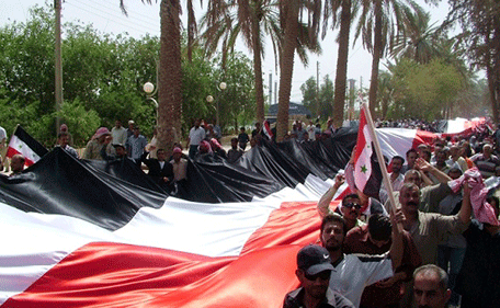 Syrian carry a giant national flag during a rally in the eastern province of Deir el-Zour, Syria, Thursday, July 28, 2011. A global campaigning organization said Thursday that one person disappears in Syria every hour and that almost 3,000 people have gone missing since the start of the uprising against President Bashar Assad more than four months ago.(AP)