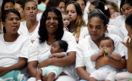 Inmates hold their babies as they watch fellow prisoners take part in the third annual Miss Penitentiary beauty pageant at the Women's Prison of Brasilia in Brasilia August 9, 2011. (REUTERS)