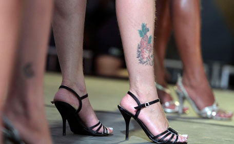 An inmate shows her tattoo while participating in the Miss Penitentiary beauty contest at the Women's Prison of Brasilia, Brazil, Tuesday Aug. 9, 2011. Miss Penitentiary is an annual contest that takes place in several Brazilian prisons with the participation of nearly 100 inmates. (AP)